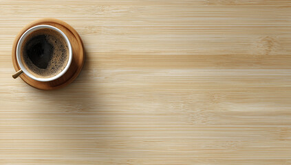 Photo of a cup of coffee on a wooden table seen from a top down perspective