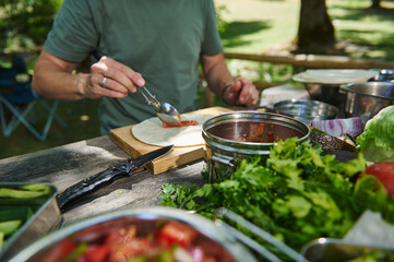 Preparing a Fresh Outdoor Meal with Fresh Ingredients in a Scenic Park Setting