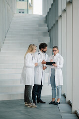 Fototapeta premium Doctors discussing patient data using tablet in hospital corridor