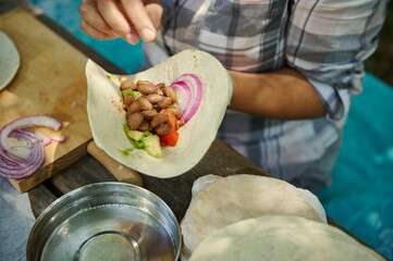 Preparing a Fresh Vegetarian Burrito Outdoors with Healthy Ingredients
