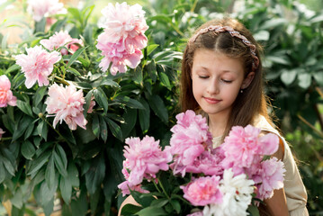 Naklejka premium girl with bouquet of pink peonies in the garden