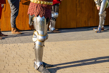 medieval knights in plate armor standing on cobblestone ground, historical reenactment scene