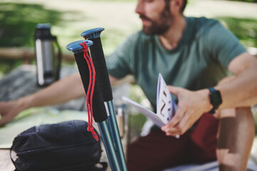 Casual Outdoor Activity with Trekking Poles and Navigational Documents in Nature