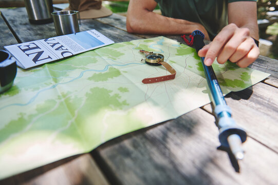 Explorer Preparing for Adventure with Map and Hiking Gear Outdoors