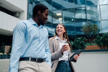 Business colleagues walking and talking outside office building
