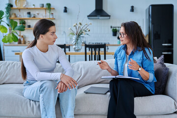 Serious teen girl in session in office of professional psychologist, therapist