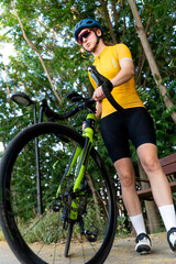 Professional cyclist holding her racing bicycle in a park