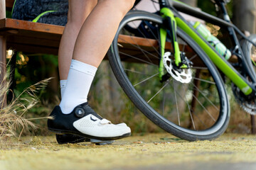 Professional cyclist resting on bench with racing bicycle