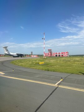 Kurumoch Airport Samara, Russia June 01, 2025. Airport fire station on the airfield with fire trucks inside. Nearby on the runway is an IL 76 aircraft