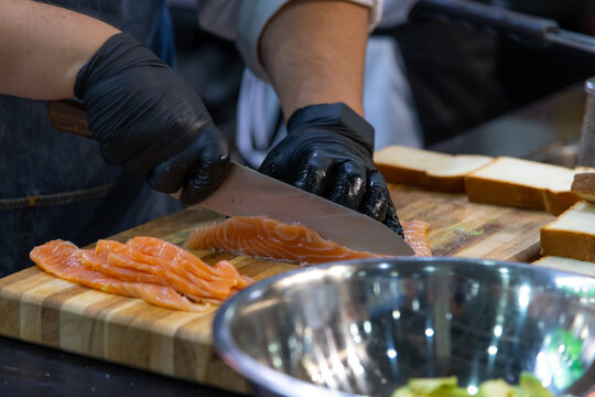 Expert cook prepares salmon fillets for a delicious appetizer in the kitchen