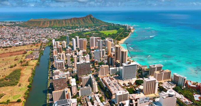 Sunny scenery of a beautiful Waikiki resort on the shore of the Pacific Ocean. Aerial perspective on the Ala Wai Canal and the Diamond Head Crater.