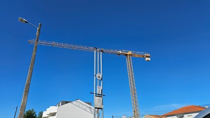 Construction Crane Towering over Modern White Buildings