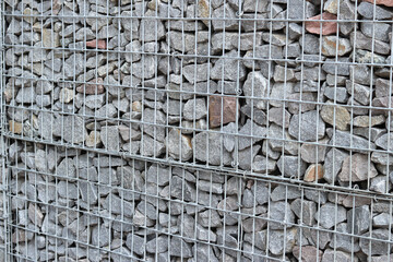 Rubble stone in galvanized mesh. Background. Gabion mattress made of woven mesh with stones for...