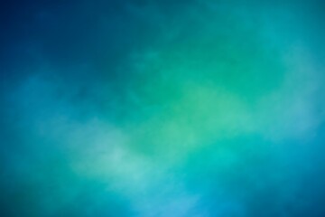 Abstract soft focus background with a gradient of deep blue and vibrant teal green colors creating a dreamy ethereal atmosphere