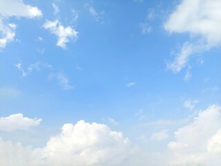 Blue sky background with white clouds in summer. Soft white clouds float in the clear blue sky. Clear blue sky, bright spring, soft sky gradient, wallpaper landscape, aerial view.