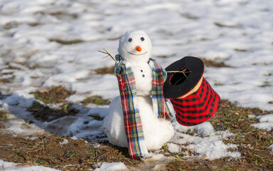 Snowman wait spring. Snowman is melting on spring day. Winter and spring, warm winter. Melted snow,...
