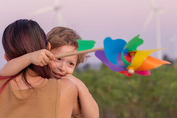 Family with son walking on field on wind farm. Happy Family and son playing at the Wind turbines...