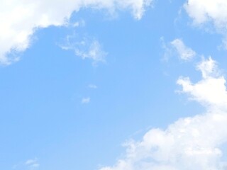 Sky and cloud gradient background. A very bright, dramatic blue sky covered in wisps of soft, wispy clouds against the backdrop of a peaceful daytime scene. The sun was shining hot.