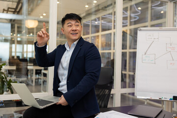 Young asian businessman working on a laptop in his office