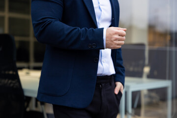 Close up picture of a man in a suit with his hand in the pocket