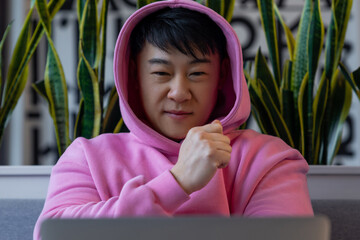 Asian young man at the laptop looking serious and concentrated