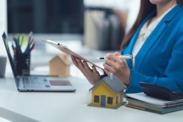 Real Estate Review: A real estate professional meticulously reviews paperwork, pen in hand, with a...