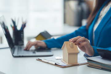 Property Planner's Desk: A focused professional engages with property planning tools, with a model...