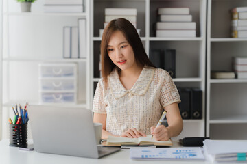Focused Productivity: A young woman is deeply concentrated, capturing her focus as she uses a...