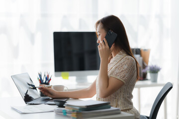 Focused and Connected: A professional works diligently at a desk, multitasking with a phone call...