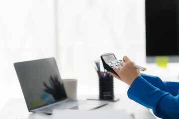Financial Calculations: A close-up shot captures a professional's focused hands expertly using a calculator to meticulously handle financial calculations in an organized workspace.