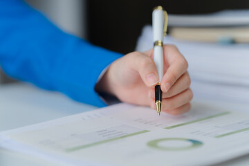 Focused Intent: A close-up shot captures a hand gracefully wielding a pen, poised to record...