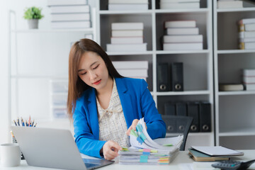 Focused Professional: A dedicated professional meticulously reviews documents in a well-organized...
