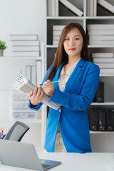 Confident Professional in Office: A poised woman, elegantly attired, stands in a modern office,...