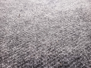 
A low-angle view highlights the textured surface of a grey carpet, with subtle patterns and soft fibers, extending across an indoor room.