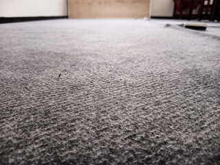 
A low-angle view highlights the textured surface of a grey carpet, with subtle patterns and soft...