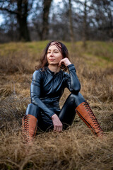 Girl in a field wearing a leather jumpsuit. Catsuit
