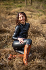 Girl in a field wearing a leather jumpsuit. Catsuit