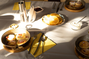 served table cottage cheese pancakes with pomegranate and orange slices
