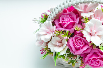 flower-shaped soap floral arrangement with pink roses and white flowers in a woven basket