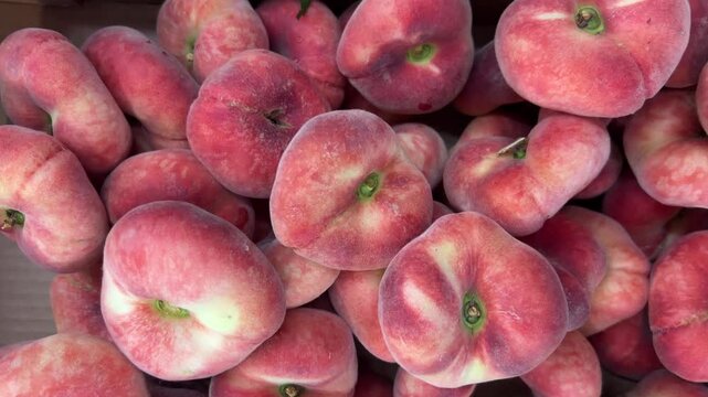 Saturn flat peaches in boxes, tracking shot in top view on doughnut peaches displayed at the grocery store