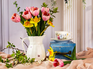 Spring still life with beautiful bouquet of pink tulip flowers, yellow daffodils in a white vintage...