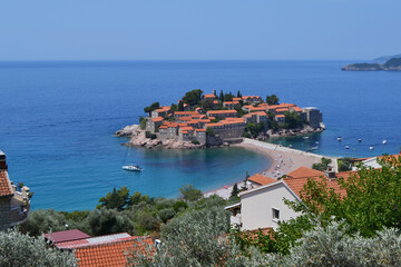Obraz premium Breathtaking Panoramic View of Sveti Stefan Island in Montenegro, Showcasing its Historic Red-Roofed Buildings, Pristine Beaches, and Azure Adriatic Sea