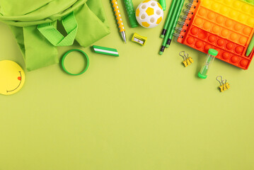 Back to school concept. Border made of school supplies on green background. Top view. Copy space