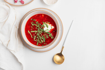 Traditional Ukrainian borscht with sour cream, garlic and rye bread on white table. Top view