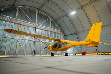 Yellow airplane glider in the hangar. 