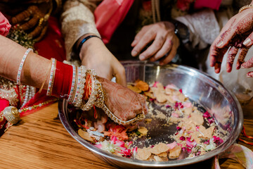 Close-up of an individual adorned with bangles, handling a tray of food, with a focus on the...