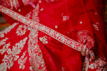 Bridal Elegance: A close-up capturing the intricate embroidery and vibrant red hues of a...