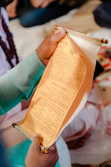 Ceremonial Document: Hands holding a scroll with astrological charts and inscriptions. A formal and...