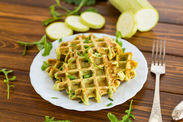 Zucchini waffles with herbs on a wooden table