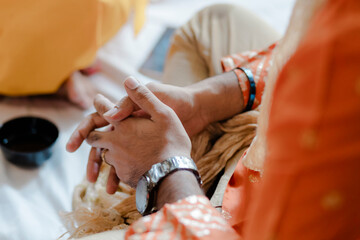 Close-up of hands, adorned with a watch and ring, suggesting commitment and attention to detail in...